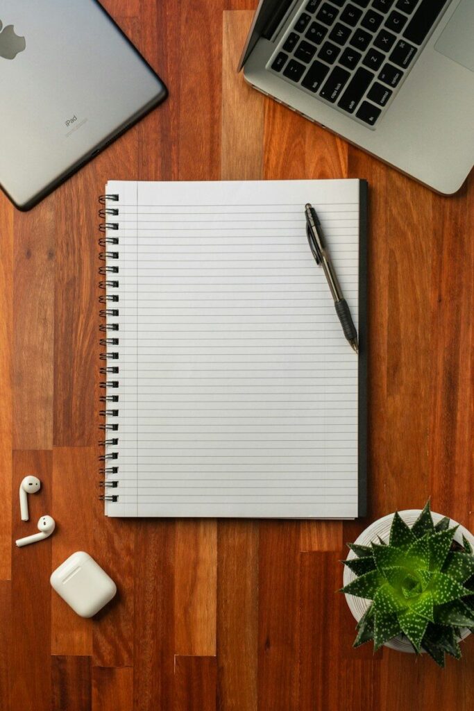 Portátil y cuaderno de notas en la mesa de la redacción de 140bytes